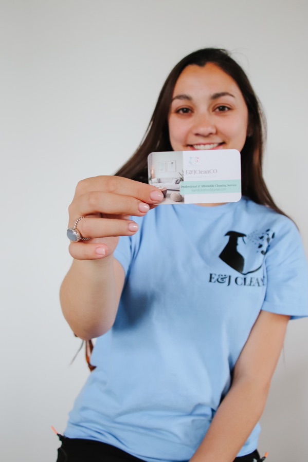 Alanah Evans, owner of E&J Clean Co, holding an E&J Clean Co business card